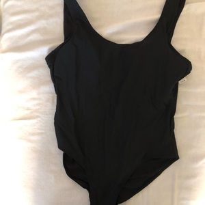 Black swimsuit with tags and liner is still in crotch area.